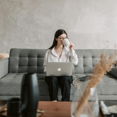 Woman Drinking Coffee While Working With Laptop