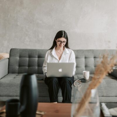 Woman Smiling While Using Laptop