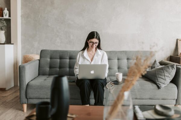 Woman Smiling While Using Laptop